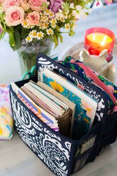 an open wallet sitting on top of a table next to a vase filled with flowers