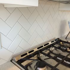 a stove top oven sitting inside of a kitchen next to a wall mounted range hood