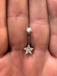 a person's hand holding an engagement ring with a star design on the side