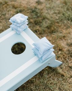 a close up of a blue and white cornhole game on the ground with towels