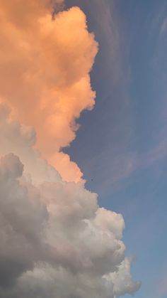 an airplane is flying in the sky with clouds