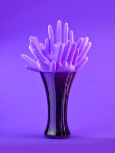 a purple vase filled with lots of white toothbrushes