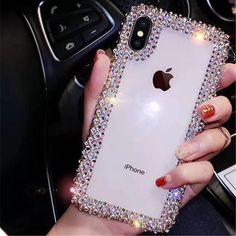 a woman holding an iphone in her hand with some diamonds on the back and sides