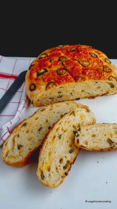 a loaf of bread sitting on top of a white cutting board next to a knife