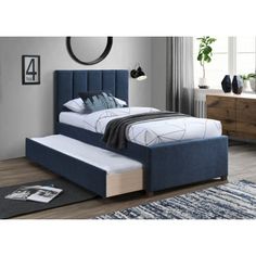 a bed with a blue upholstered headboard and foot board in a bedroom