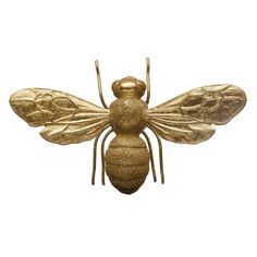 a golden bee sculpture sitting on top of a white surface