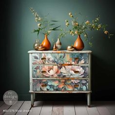 two vases sitting on top of an old dresser with flowers painted on the drawers