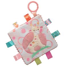 a pink and white giraffe on a patchwork cloth with ribbon around it