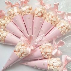 pink and white candy cones wrapped in cellophane with bowknots on them