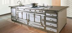 an old fashioned stove and sink in a room with wood flooring on the side