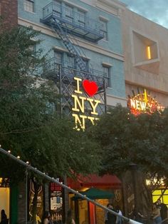 people walking in front of a building with a sign that says i love new york