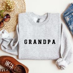 Introducing the "Grandpa" Sweatshirt - a handmade, custom gift designed for Grandma's birthday, Father's Day, or as a birth announcement celebration. This cozy sweatshirt is a unique and heartwarming way to commemorate her role as a new grandparent. Crafted with love, it features personalized elements and ensures both comfort and durability. A thoughtful and cherished keepsake, the "Grandpa" Sweatshirt is a perfect way to embrace the joy and pride of being a grandparent. * Custom text is availab Cotton Sweatshirt With Lettering For Gift, Father's Day Casual Sweatshirt Gift, Casual Father's Day Gift Sweatshirt, Father's Day Crew Neck Sweatshirt As Gift, Father's Day Gift Crew Neck Sweatshirt, Relaxed Fit Name Print Sweatshirt Gift, Crew Neck Sweatshirt With Custom Text For Gift, Customizable Relaxed Fit Sweatshirt For Gift, Crew Neck Sweatshirt With Name Print As Gift