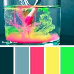 a glass filled with colorful liquid and paintbrushes