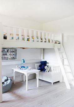 there is a bunk bed in the room with white furniture and blue decorations on it