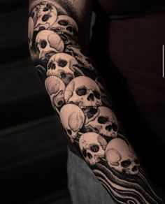 a man's arm with many skulls on it