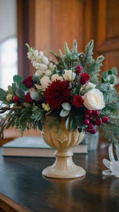 a vase filled with flowers sitting on top of a wooden table