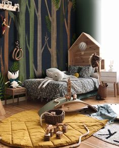 a child's bedroom with an animal theme on the wall and toys in the floor