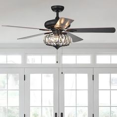 a living room with a ceiling fan and chandelier hanging from it's ceiling