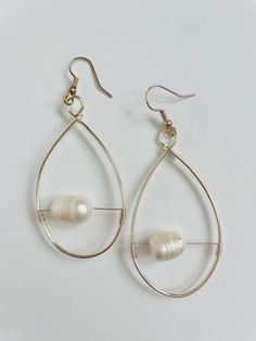 "Introducing the captivating \"Whispering Pearls\" Earrings by Katie Anne. These exquisite earrings are a true embodiment of elegance and grace. Delicately crafted with a unique design, they feature beautiful white pearls seemingly suspended within a teardrop-shaped hoop, creating a mesmerizing floating effect. The \"Whispering Pearls\" Earrings are a stunning addition to any jewelry collection, perfect for those special occasions or simply adding a touch of sophistication to your everyday look. Wear Pearls, Pearls Earrings, Alexandria Va, Freshwater Pearls Earrings, New Classic, Cute Bows, Pearl White, Timeless Beauty, Everyday Look