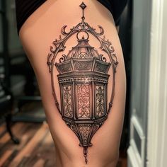 a woman's thigh with an ornate lantern tattoo on it