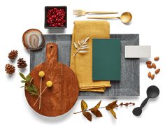 a table topped with lots of different types of food and utensils on top of a wooden cutting board