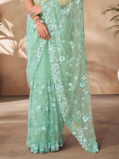 The bewitching mint green sequins net designer saree comes with intricate thread work, sequin work, and zarkan work, adding a touch of elegance and charm to your ensemble. The matching mint green net blouse also features the same embellishments, creating a coordinated and stunning look.
This saree includes the delicate thread work that enhances the overall design, the shimmering sequin work that adds a touch of glamour, and the intricate zarkan work that gives a traditional twist to the outfit. Green Pre-draped Saree With Intricate Embroidery For Festivals, Eid Party Wear Net Saree, Green Pre-draped Saree With Intricate Embroidery For Eid, Green Embroidered Party Wear Dupatta, Eid Green Pre-draped Saree With Intricate Embroidery, Eid Green Net Lehenga, Green Net Lehenga For Eid, Green Net Diwali Set, Green Embroidered Party Saree