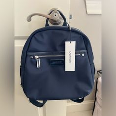 This Backpack From Calvin Klein Is Ready For Anything With A Compact Silhouette And Durable Nylon Construction. Medium Sized Bag; 10"W X 11-1/2"H X 4-1/2"D (Width Is Measured Across The Bottom Of Backpack) 10"L Backpack Straps Zip Closure Silver-Tone Hardware 2 Interior Slip Pocket & 1 Zip Pocket 1 Back Slip Pocket, 1 Front Slip Pocket, And 1 Front Zip Pocket Why You'll Love It: A Nylon Bag Is Your Go-To Bag, Ready For Any Day, Any Weather. It's Lightweight, Durable And Water-Resistant! Nylon; T Calvin Klein Bags, Calvin Klein Bag, Medium Sized Bags, Klein Blue, Backpack Straps, Nylon Bag, Womens Calvin Klein, Blue And Silver, Zip Pockets