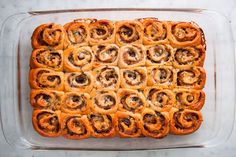 a casserole dish filled with different types of pastries on top of a table