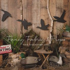 there are many birds flying over the table and in front of the wall with plants