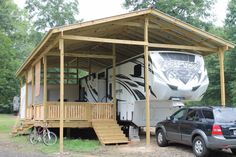 a truck is parked in front of a house with a camper attached to it