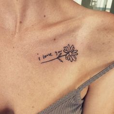 a woman's chest with a flower tattoo that says i love you on it