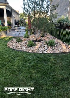 a rock garden bed in the middle of a yard