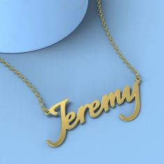 a gold necklace with the word jeremy hanging from it's side on a blue surface