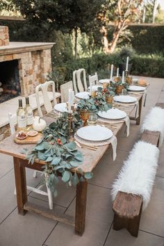 an outdoor table set up with white chairs and place settings