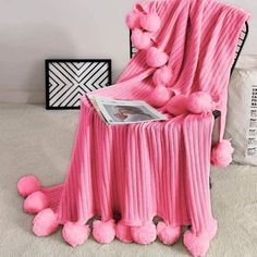 a pink chair with pom - poms on it