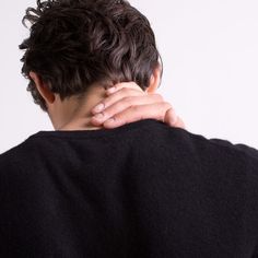 the back of a man's head with his hands on his neck and shoulder