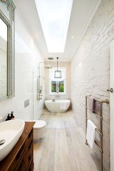 an image of a bathroom with white walls and wood flooring on the right side