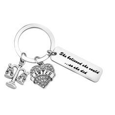 a keychain with two charms and the words, she returned to our heart