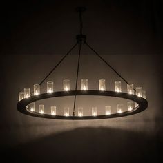 a chandelier with many lit candles hanging from it's sides in a dark room