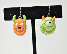 This listing is for one pair of lightweight, mismatched monster earrings.  Charm: (Measurement is from top of earwire to bottom of charm. The measurement may change slightly if you upgrade earwires.) * Plastic * Orange Monster - 32 mm long x 16 mm wide * Green Monster - 32 mm long x 18 mm wide Earwires: * The earwires are stainless steel and come with a clear back.  * I offer silver plated clip-on earrings and sterling silver hooks as well. Made from repurposed materials. Clear glue shows on the back. If you have any questions please send me a message.  Please visit my shop to see more fun, unique jewelry! https://www.etsy.com/shop/MandaLynnCreations Monster Earrings, Orange Monster, Jewelry Halloween, Clear Back, Earrings Fall, Green Monster, Clear Glue, Earrings Halloween, Green Monsters