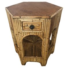 an old bamboo side table with a wooden top and drawer on the bottom, isolated against a white background