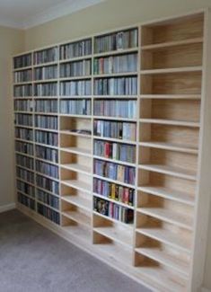 a book shelf filled with lots of books next to a wall full of shelves covered in dvds