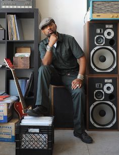 a man sitting on top of a chair next to speakers