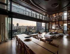 a living room filled with furniture and a large window overlooking the cityscape in the distance