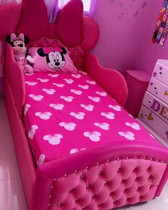 a pink bed with minnie mouse head on it