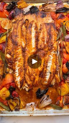 a pan filled with fish and vegetables on top of a table