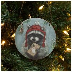 a raccoon ornament hanging from a christmas tree