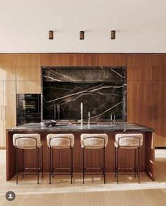 a kitchen with marble counter tops and bar stools