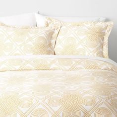 a bed with yellow and white comforters on top of it