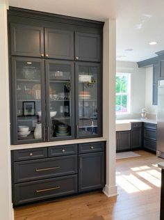 a kitchen with gray cabinets and wooden floors